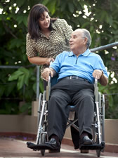 caregiver pushing elderly man in wheelchair