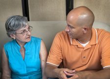 male caregiver talking with elderly woman