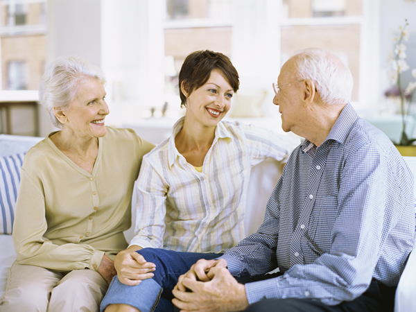 caregiver and elderly sitting with family 