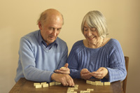 elderly couple playing dominoes