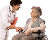 nurse speaking with elderly woman in wheelchair
